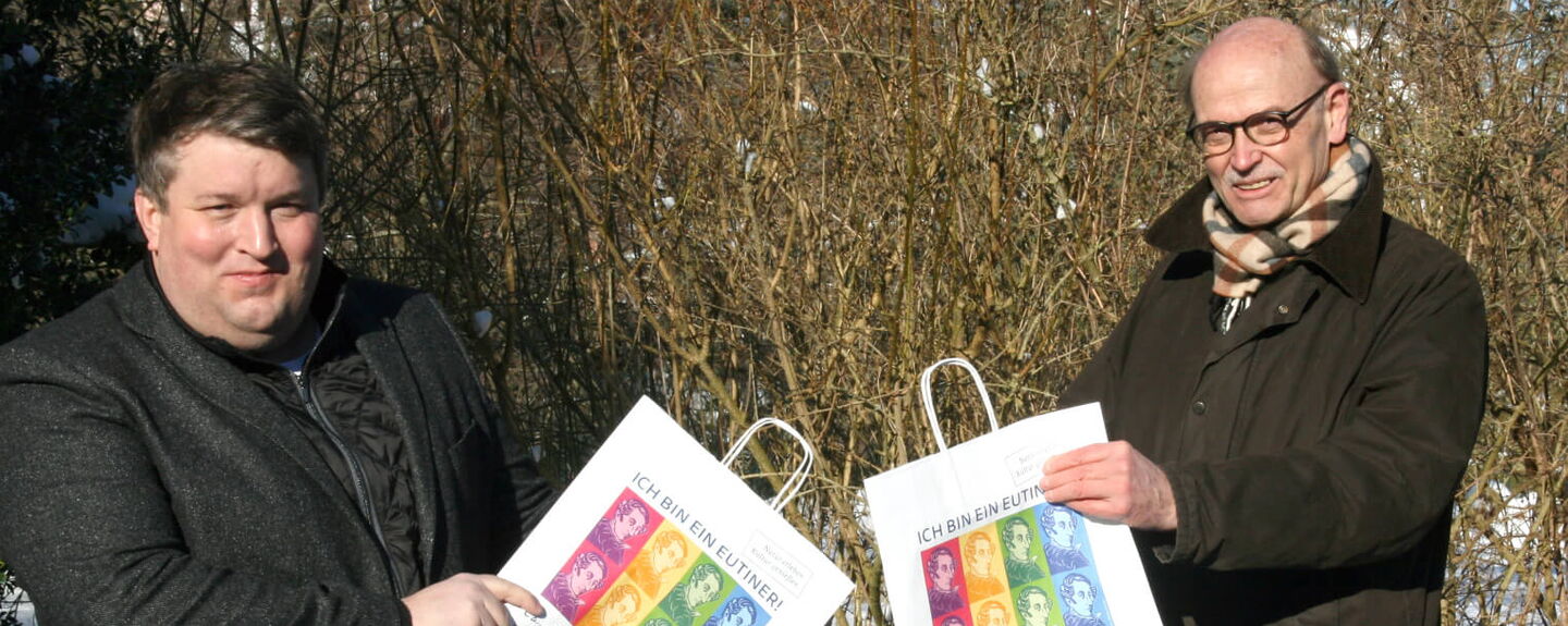 Falk Herzog und Hans-Wilhelm Hagen (WVE) präsentieren die mit Webers Portrait bedruckten Eutiner Einkaufstaschen